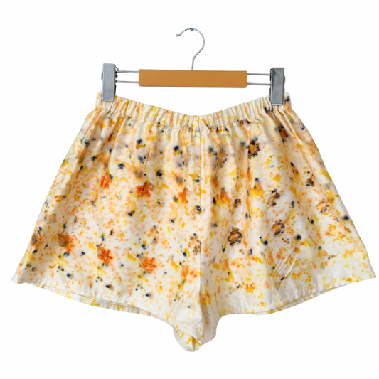 Floral-patterned shorts on a hanger against a white background.
Naturally dyed with homegrown flowers.
