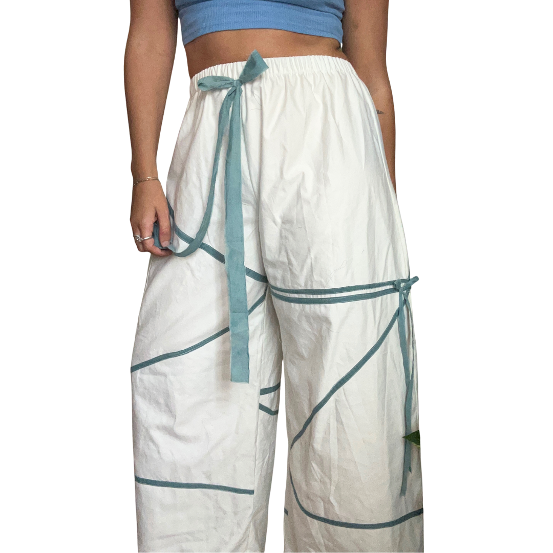 White pants with blue accents worn by a person on a white background.
Naturally dyed indigo pants.