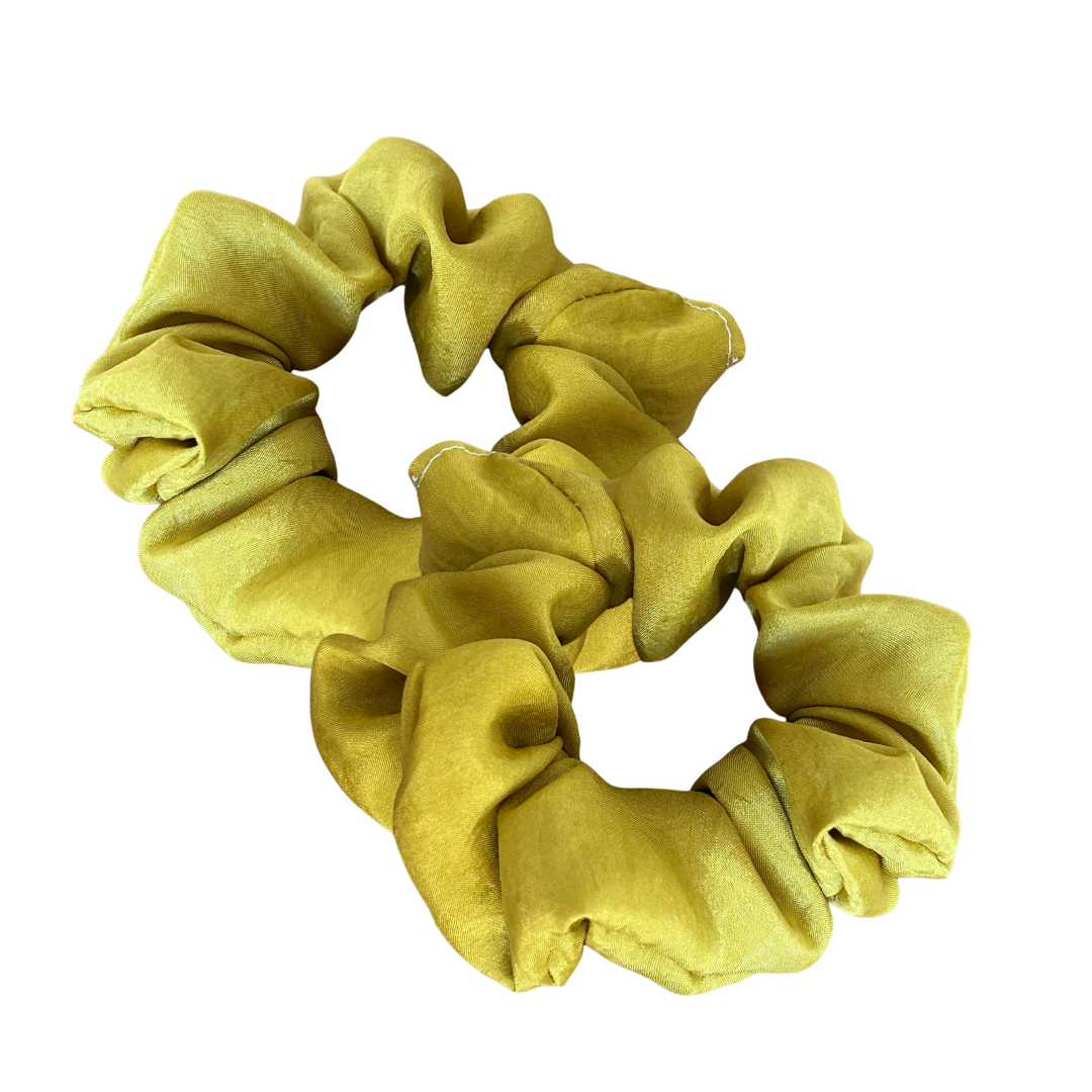 Two green 100% silk scrunchies on a white background. Naturally dyed with marigolds.