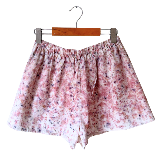 Floral patterned shorts on a hanger against a white background.
Plant dyed with sumac and scabiosa.